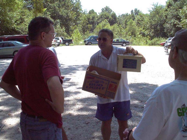 2007 - Geocacher "Island-Dave" presenting geocacher "bruces" with a gold-plated ammo box commemorating the day's event: Bruce's 1,000 geocache find.