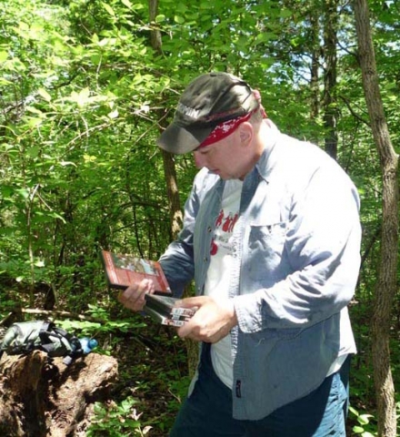 2008 - Looking at contents of "KISS" geocache in southern Missouri. This cache was big enough to have DVD movies as trinkets.